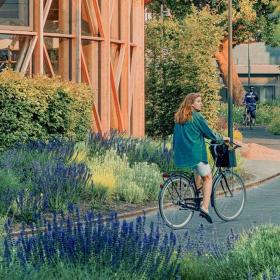 Pige på cykel ved hca hus