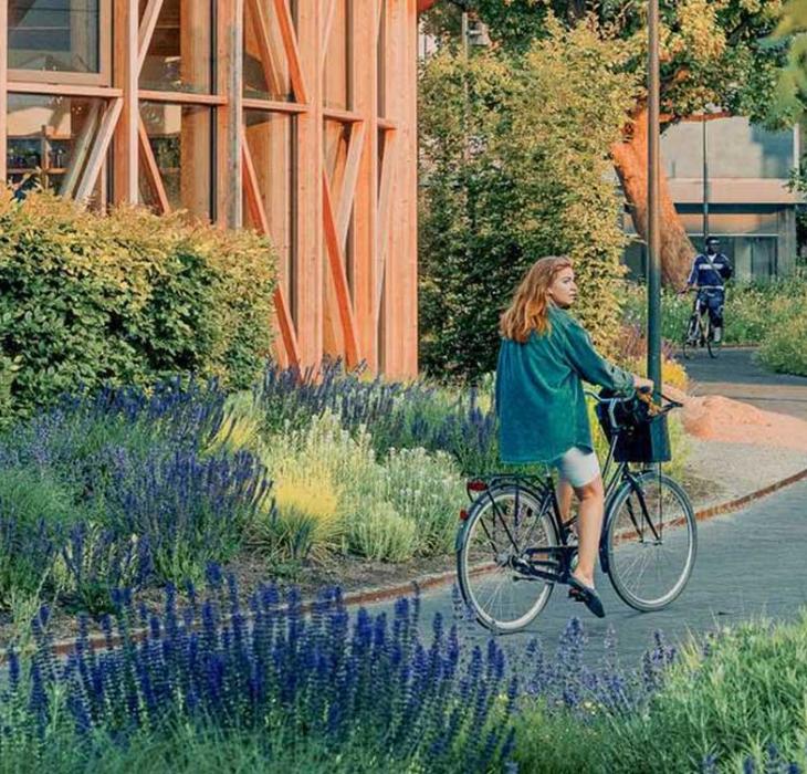 Pige på cykel ved hca hus